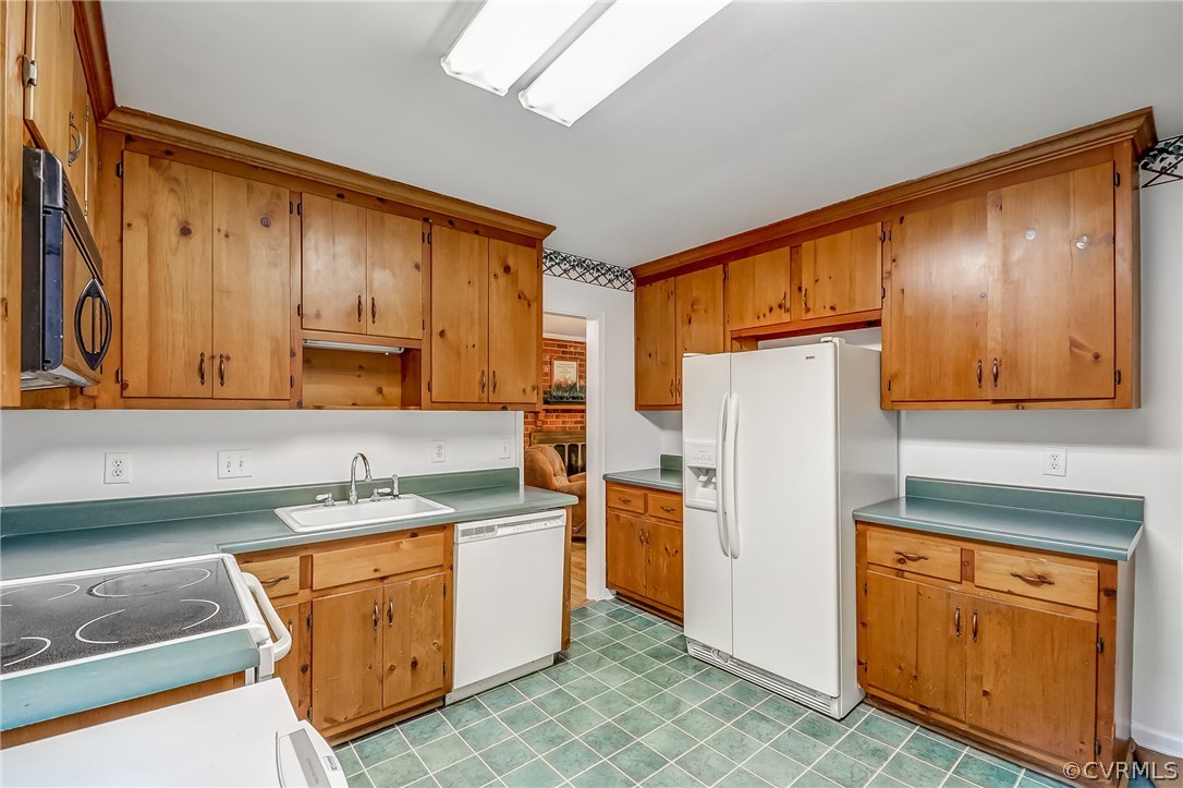 4906 Rollingway Road Chesterfield, VA 23832 - Photo 14 of 34 a kitchen with stainless steel appliances granite countertop a refrigerator a sink dishwasher stove and white countertops with wooden cabinets