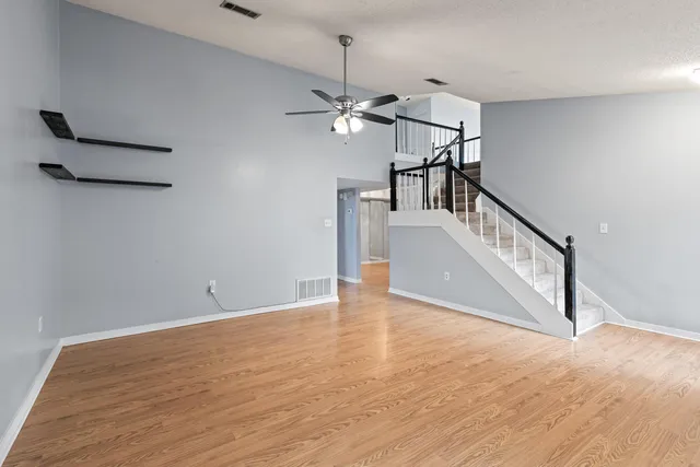 a view of empty room with wooden floor