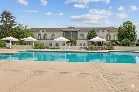 a view of a house with a yard and potted plants