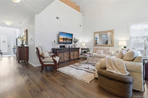 a living room with furniture wooden floor and a flat screen tv