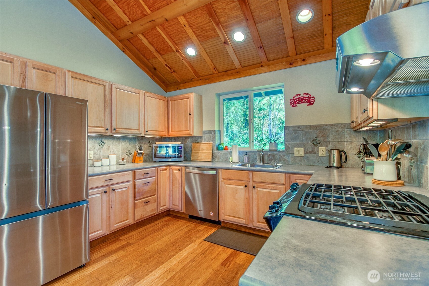 744 Tarte Road Friday Harbor, WA 98250 - Photo 8 of 35 a kitchen with stainless steel appliances granite countertop a refrigerator a sink dishwasher a stove and white countertops with wooden floor