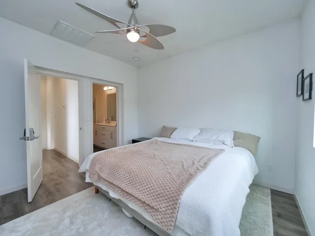 a spacious bedroom with a bed and a chandelier