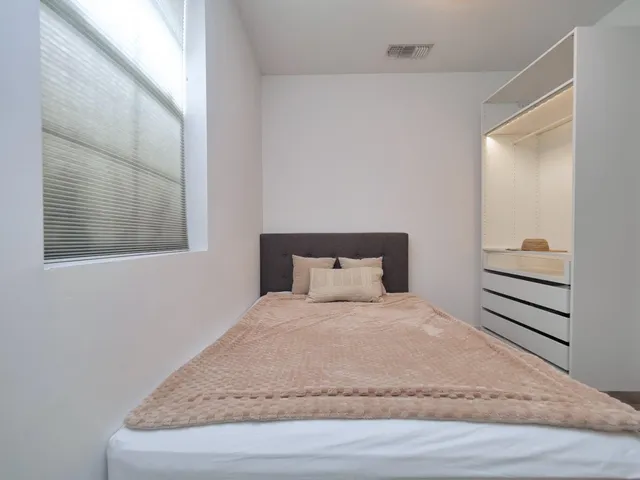 a bedroom with a bed and wooden floor