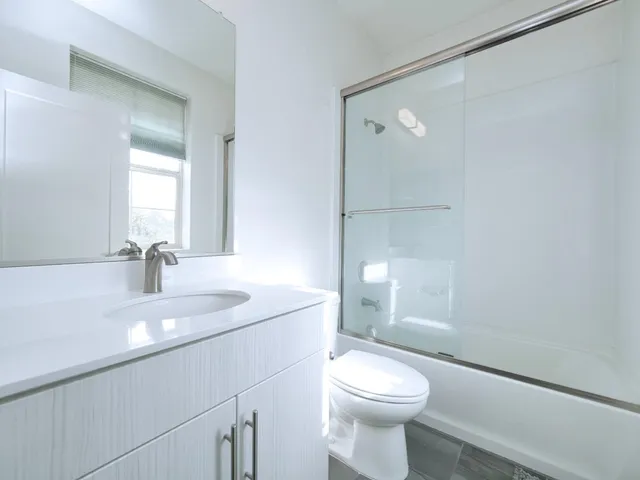 a bathroom with a sink a toilet a shower and a mirror
