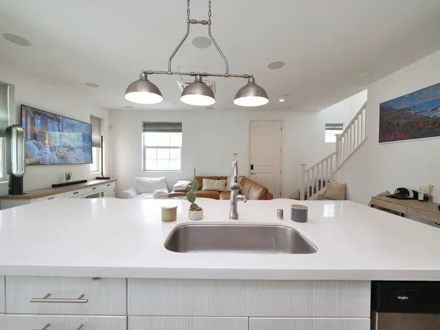 a kitchen with a sink a chandelier and window