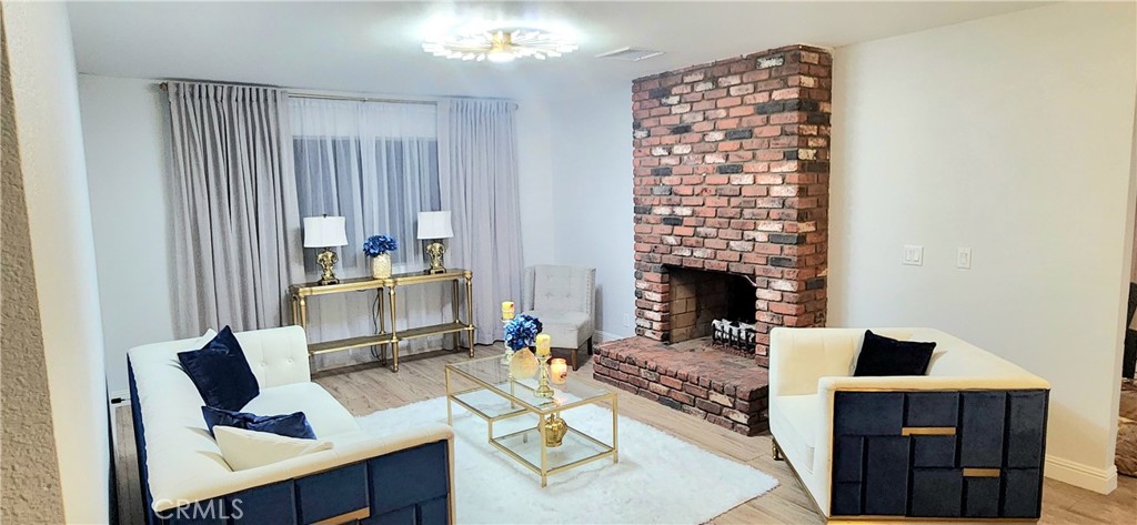 a living room with furniture a fireplace and a chandelier