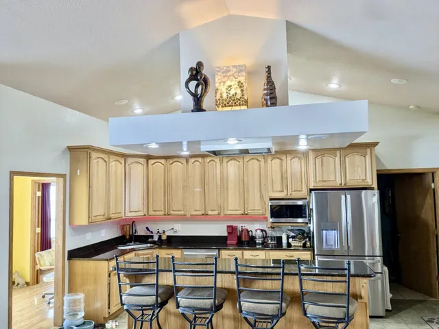 a living room with furniture kitchen view and a large window