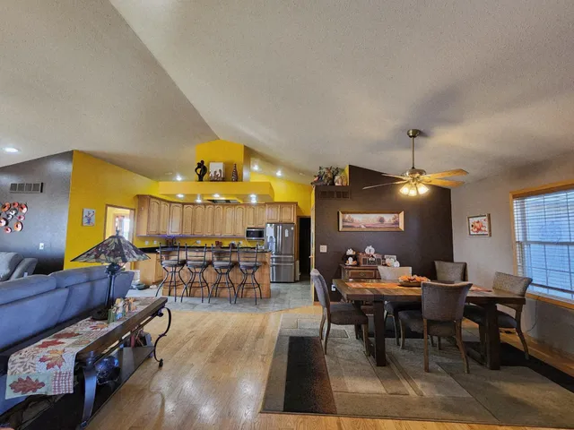 a living room with dining table and paintings on the wall
