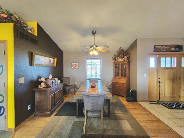 a kitchen with stainless steel appliances a dining table chairs and a refrigerator