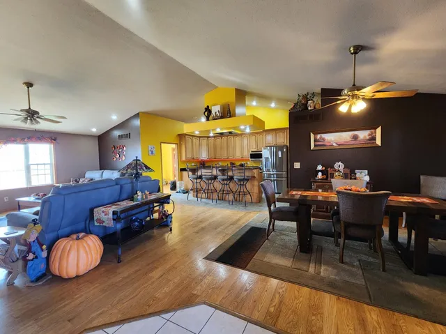 a living room with furniture a flat screen tv and kitchen view