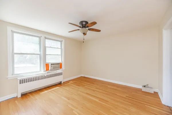 an empty room with a window and a ceiling fan