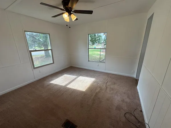 an empty room with closet and windows