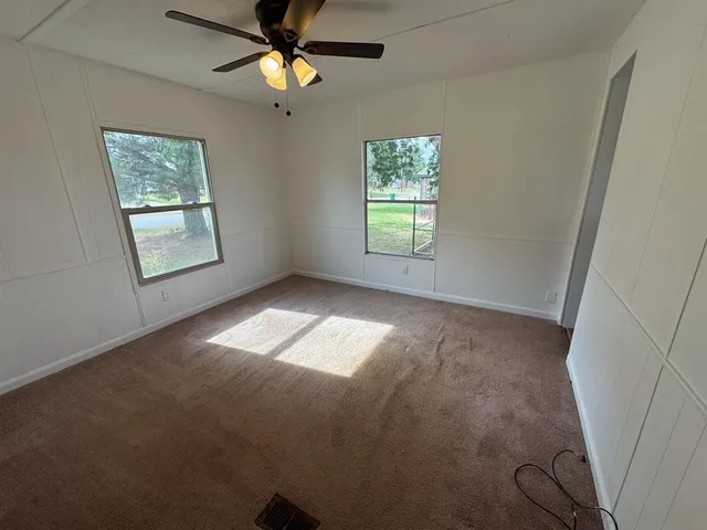 an empty room with closet and windows