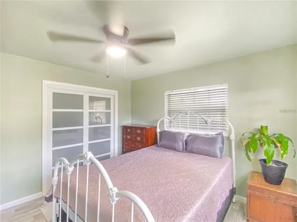 a bedroom with a bed and a potted plant