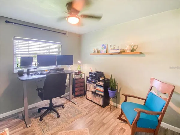 a view of a workspace with furniture and a window
