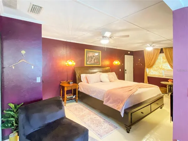 a spacious bedroom with a bed and a lamp