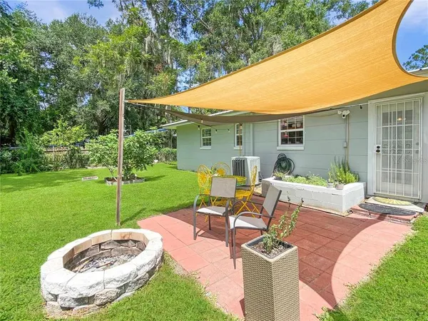 a view of backyard of house with outdoor seating
