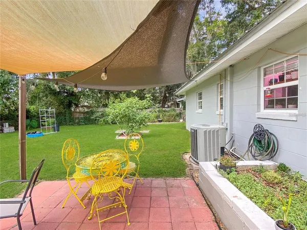 a view of a chair and tables in the backyard with a lake view