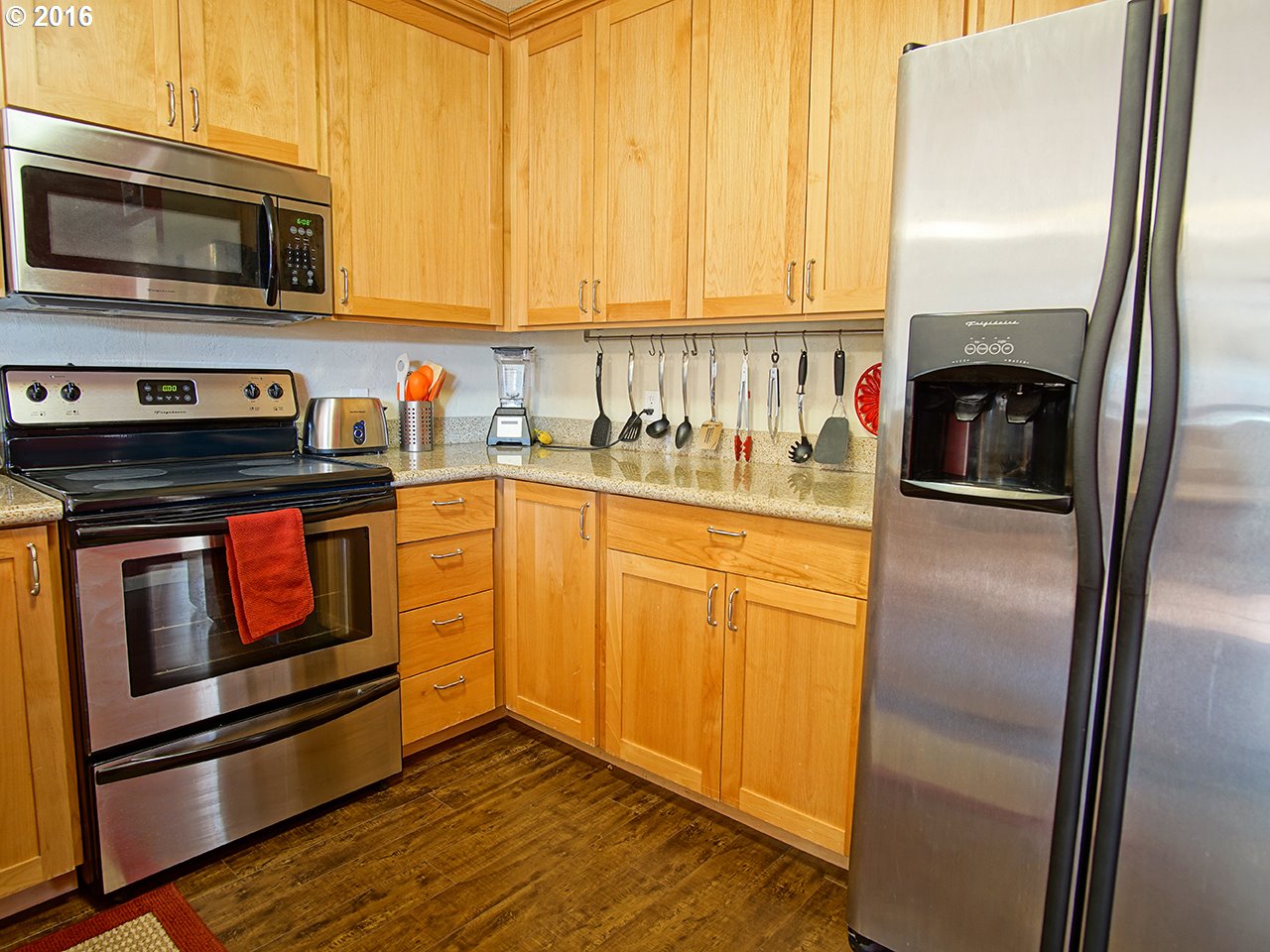 290 25th Street Springfield, OR 97477 - Photo 12 of 25 a kitchen with granite countertop stainless steel appliances and wooden cabinets
