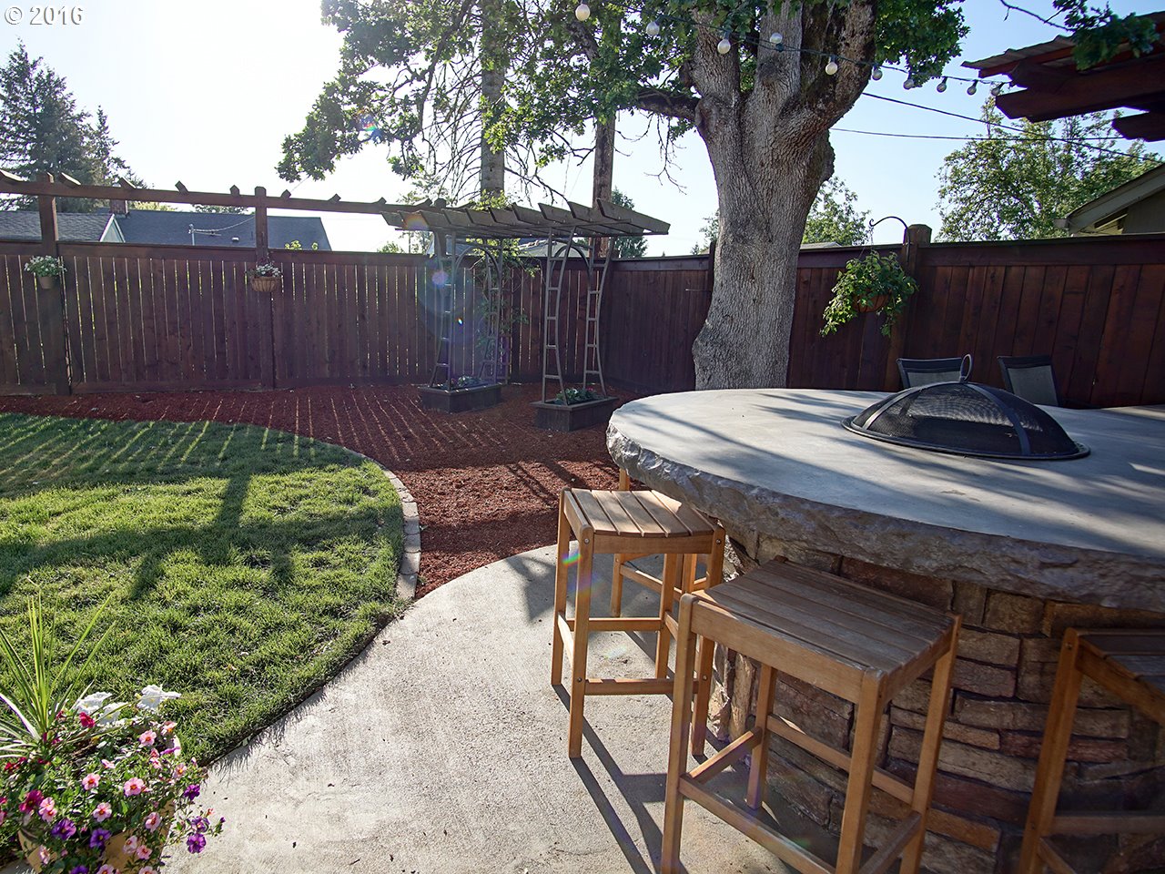 290 25th Street Springfield, OR 97477 - Photo 23 of 25 a view of a backyard with table and chairs potted plants and wooden fence