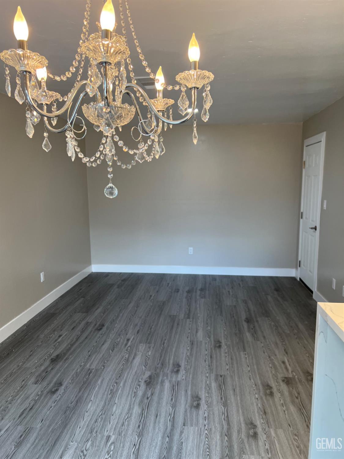 Undisclosed Address Bakersfield, CA 93308 - Photo 6 of 17 a view of a room with wooden floor and chandelier