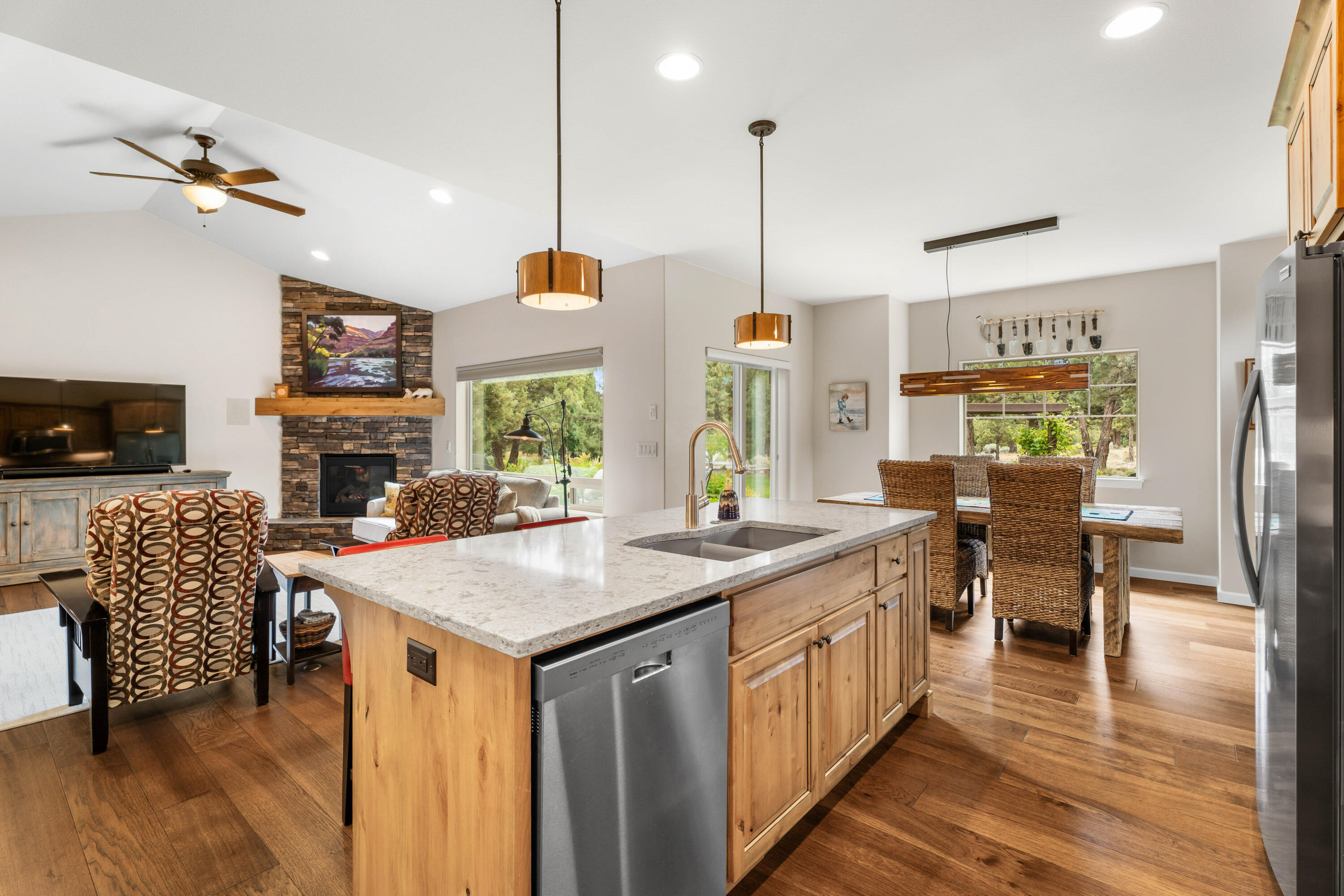 205 Vista Rim Drive Redmond, OR 97756 - Photo 12 of 85 a kitchen with stainless steel appliances granite countertop a stove a refrigerator a kitchen island a dining table and chairs with wooden floor