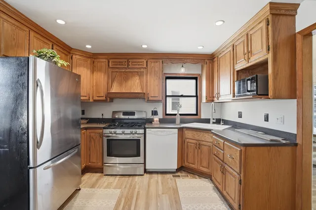 a kitchen with a stove a sink dishwasher a refrigerator and a microwave