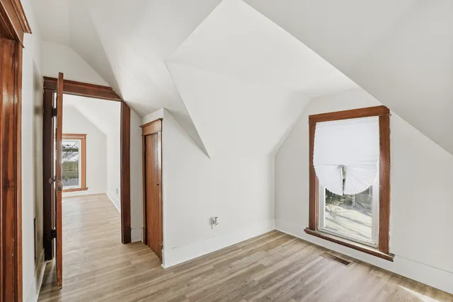 an empty room with wooden floor and door