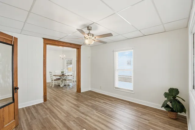 a view of a livingroom with wooden floor and a ceiling fan