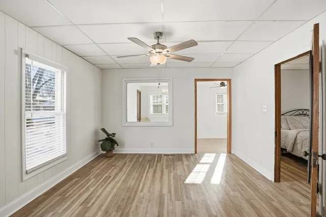 a view of empty room with wooden floor and fan