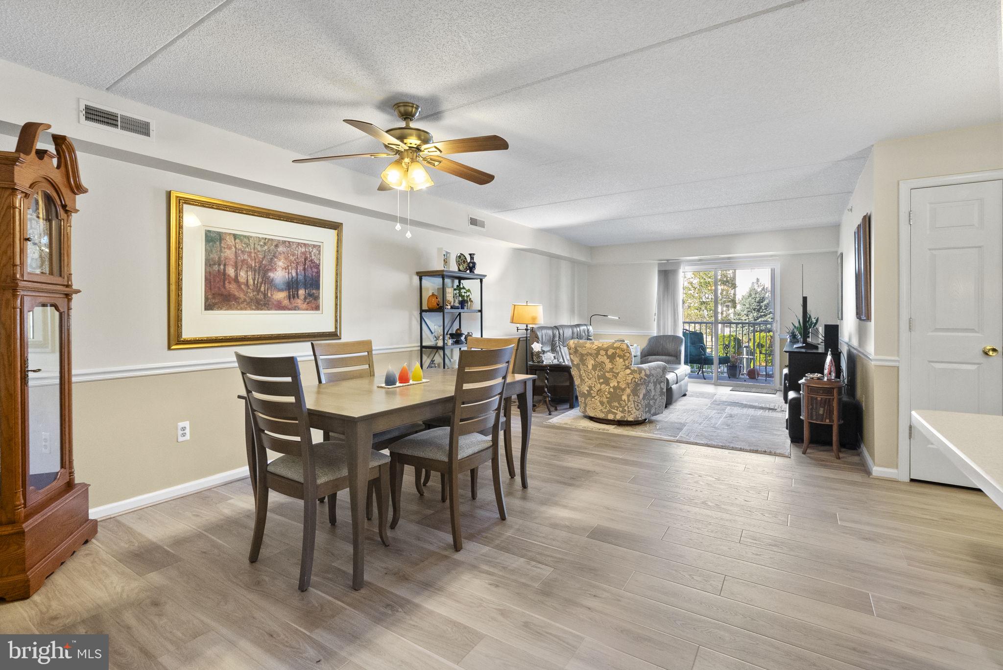 533 Brandon Road Eagleville, PA 19403 - Photo 9 of 32 a view of a dining room and livingroom with furniture wooden floor a rug a flat screen tv a painting and a chandelier