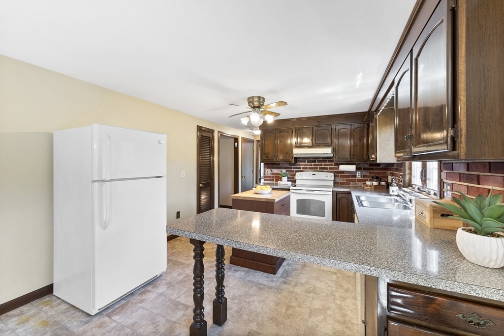 297 Granby Road Chicopee, MA 01013 - Photo 12 of 40 a kitchen with granite countertop a refrigerator a stove and a sink