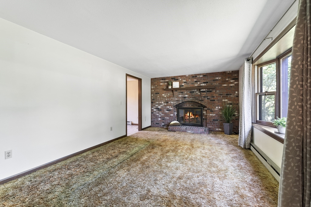 297 Granby Road Chicopee, MA 01013 - Photo 17 of 40 a view of an empty room with a fireplace and a window
