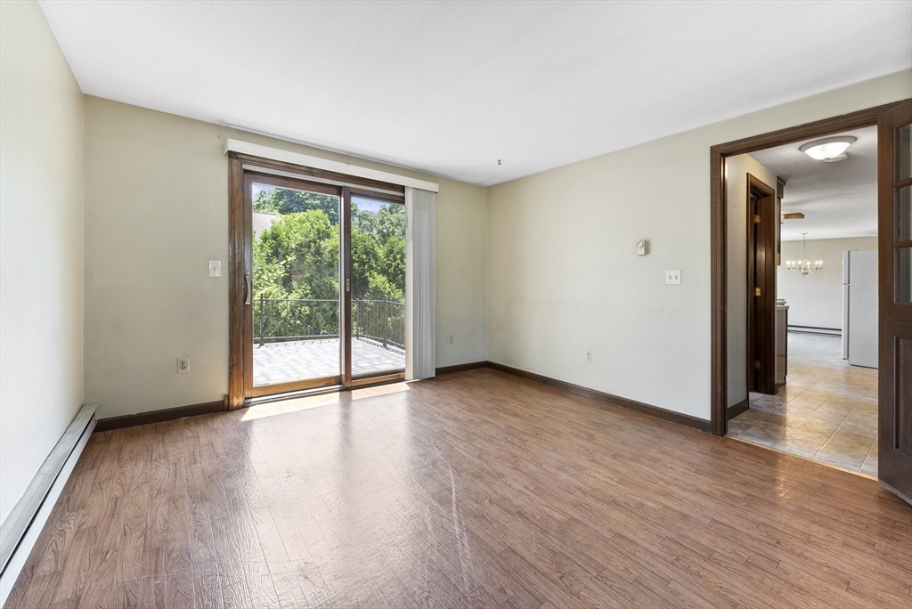 297 Granby Road Chicopee, MA 01013 - Photo 5 of 40 a view of an empty room with wooden floor and a window