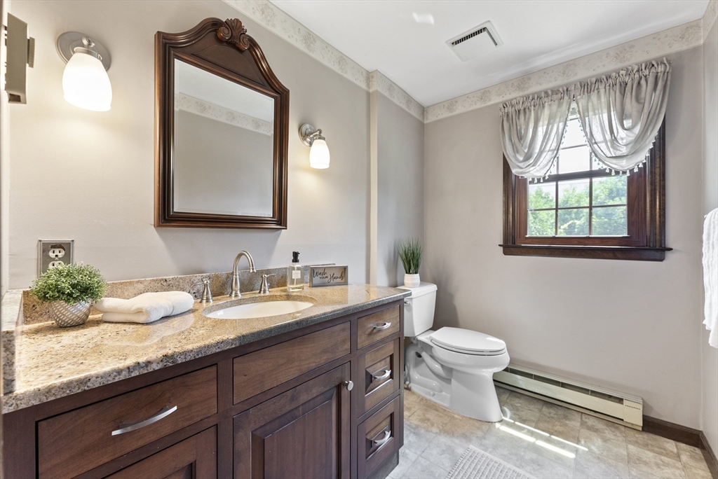 297 Granby Road Chicopee, MA 01013 - Photo 7 of 40 a bathroom with a granite countertop toilet sink and mirror