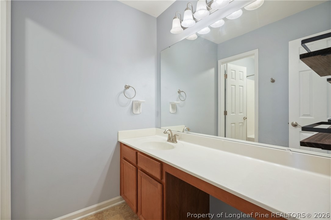 415 Highgrove Drive Spring Lake, NC 28390 - Photo 25 of 39 a bathroom with a sink a large mirror and vanity