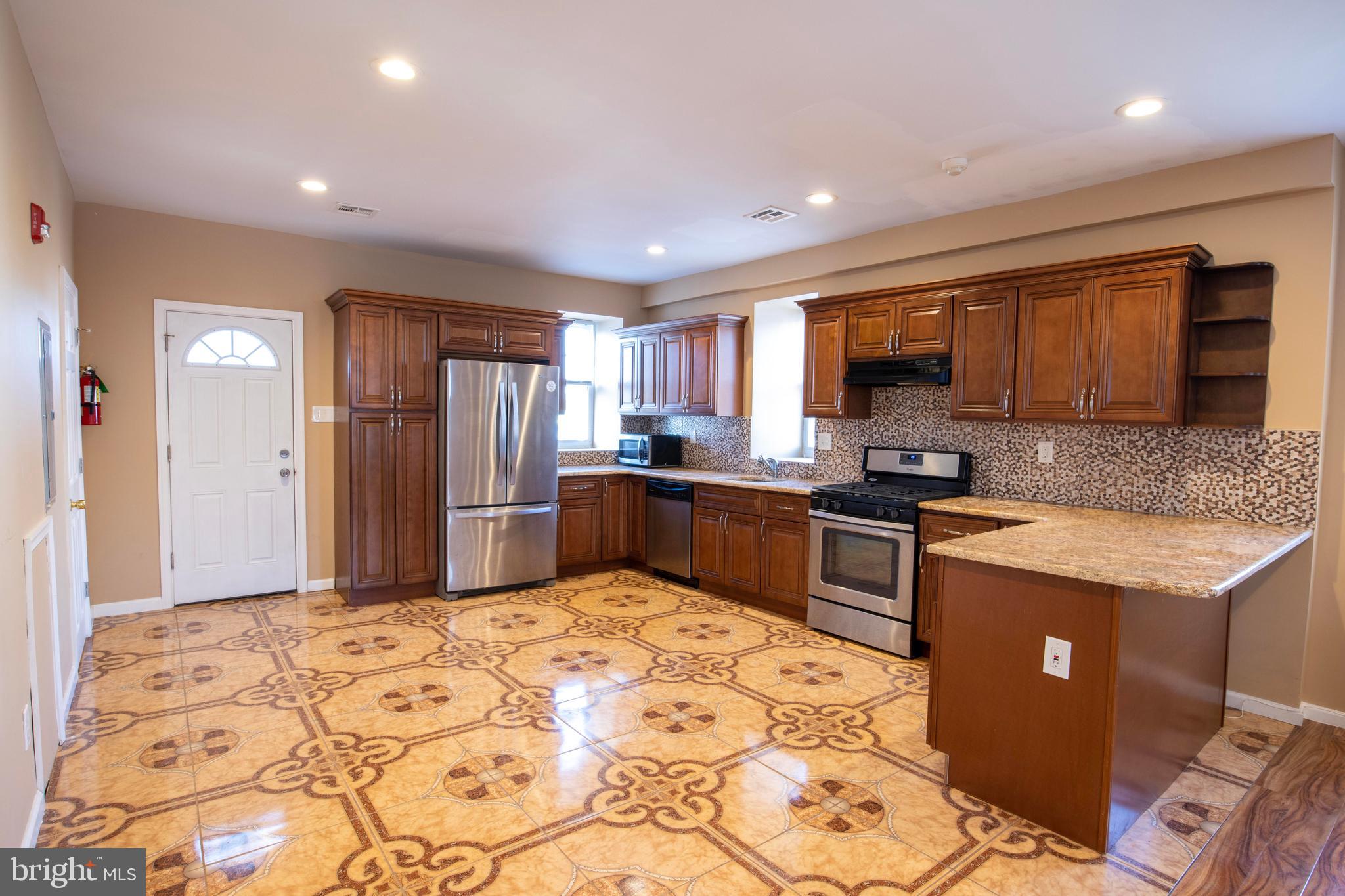 3350 Conrad Street, Unit A Philadelphia, PA 19129 - Photo 7 of 21 a kitchen with stainless steel appliances granite countertop a refrigerator sink and cabinets