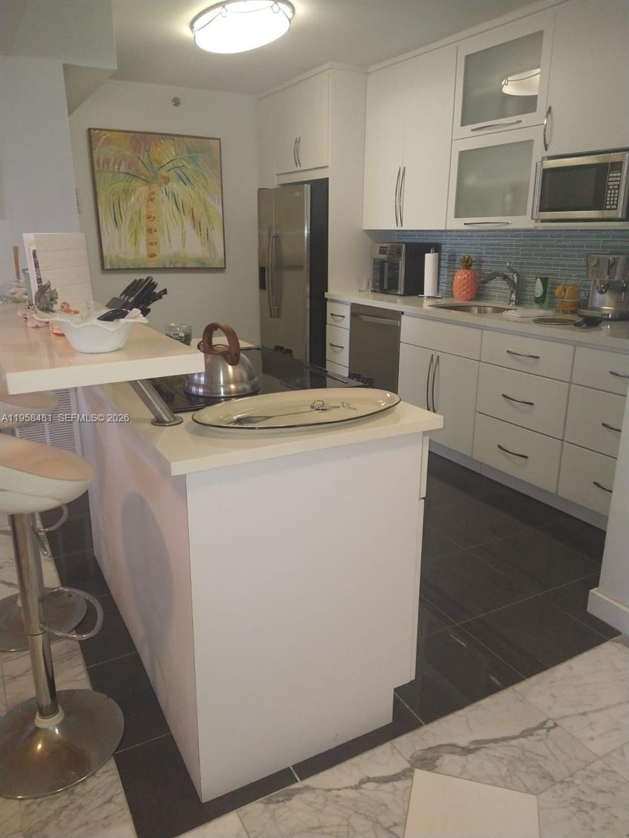 9341 Collins Avenue, Unit 806 Surfside, FL 33154 - Photo 6 of 27 a room with sink and cabinets
