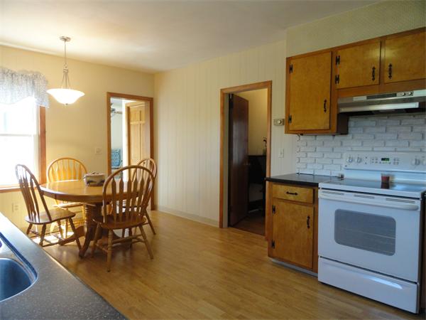 49 Glenwood Road Rutland, MA 01543 - Photo 6 of 21 a kitchen with stainless steel appliances granite countertop a stove a refrigerator a sink a dining table and chairs with wooden floor