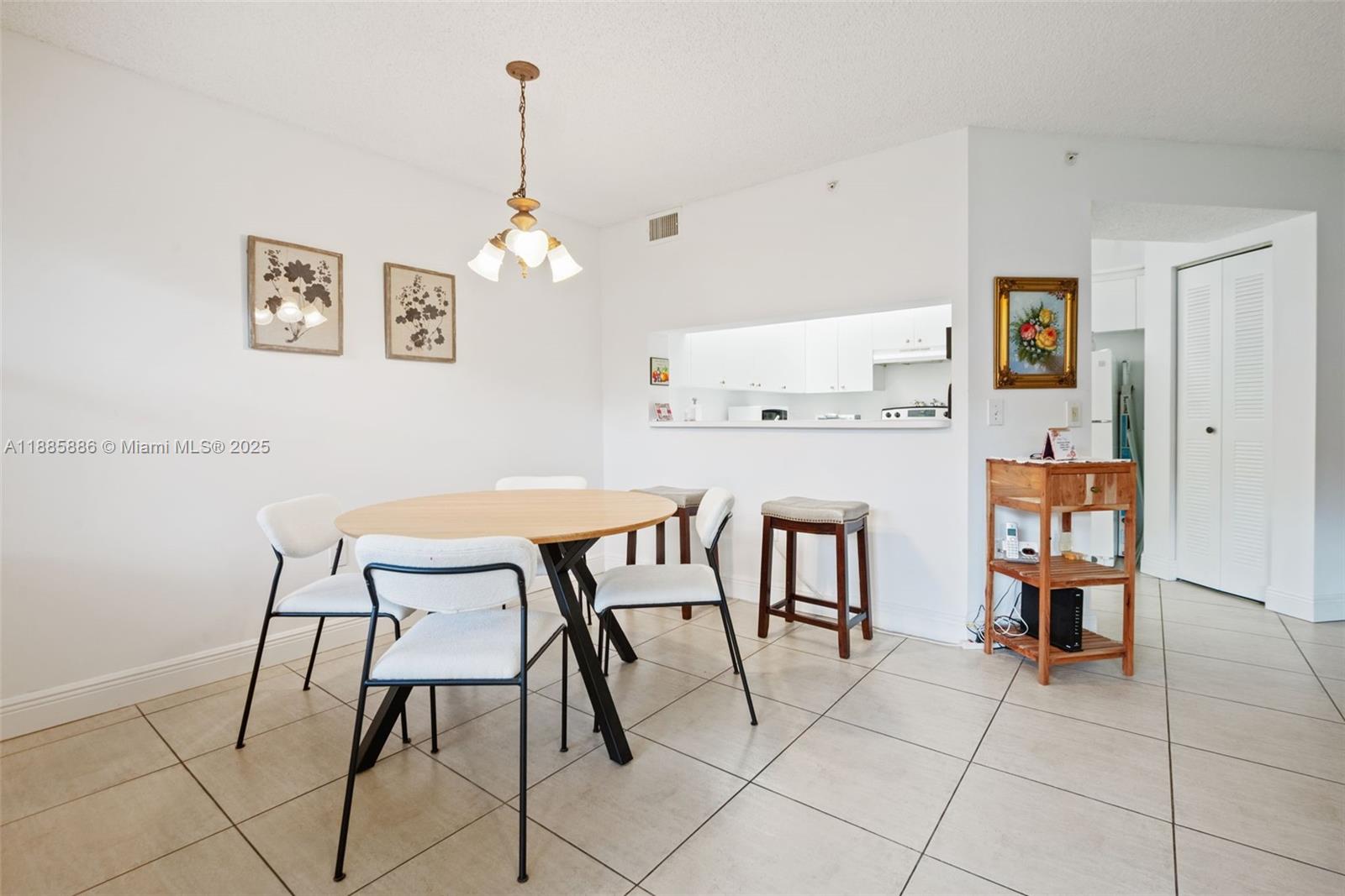 701 Southwest 142nd Avenue, Unit 110S Pembroke Pines, FL 33027 - Photo 12 of 25 a dining room with furniture and a chandelier