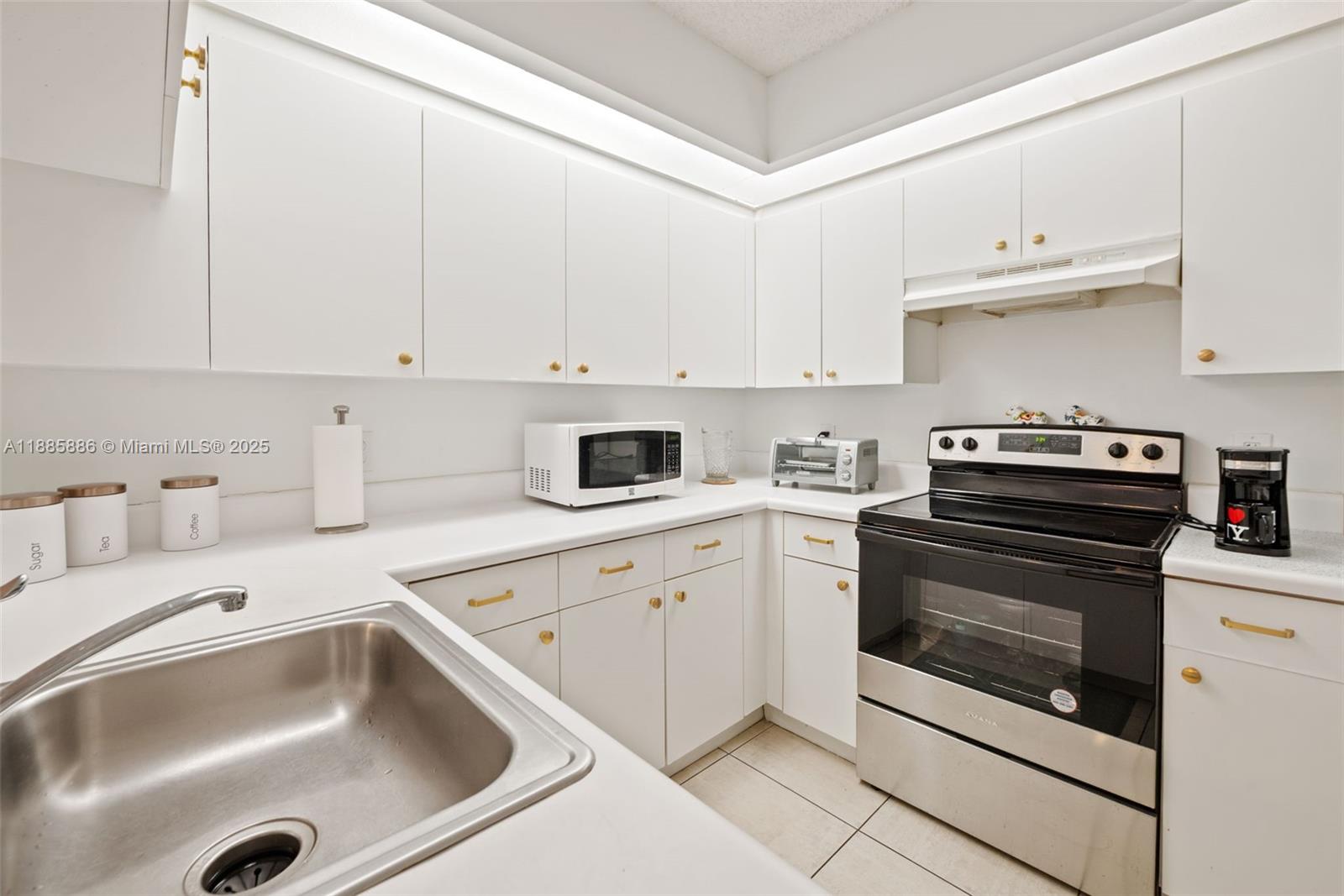 701 Southwest 142nd Avenue, Unit 110S Pembroke Pines, FL 33027 - Photo 15 of 25 a kitchen with cabinets appliances and a sink