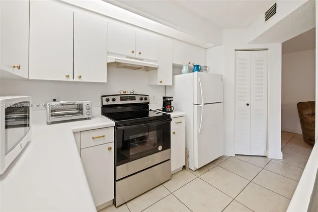 a kitchen with white cabinets and white appliances