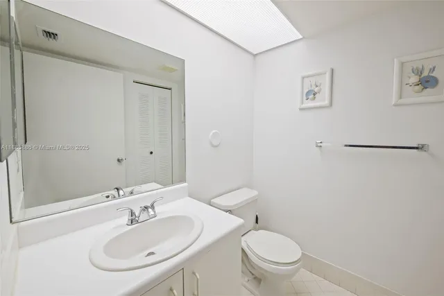 a bathroom with a sink toilet and a mirror