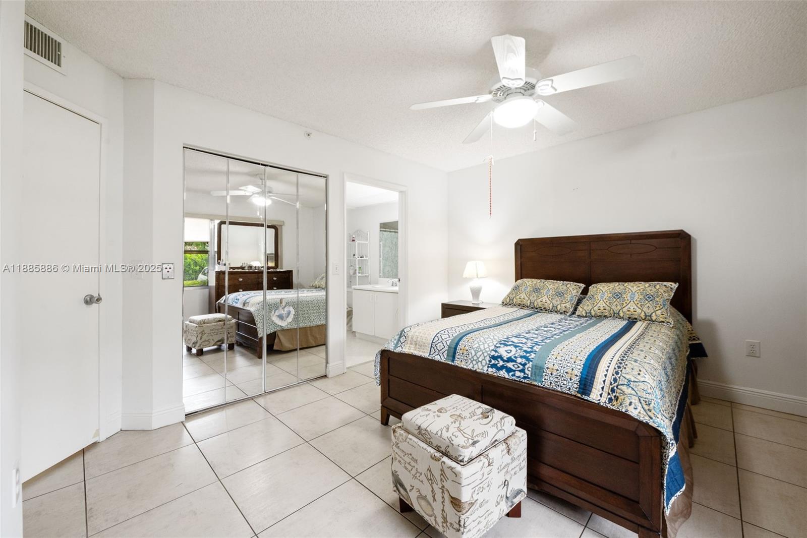 701 Southwest 142nd Avenue, Unit 110S Pembroke Pines, FL 33027 - Photo 20 of 25 a bedroom with a bed a couch and a chandelier