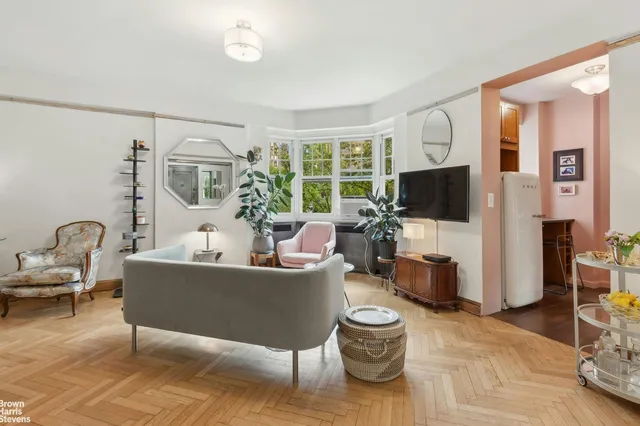 a living room with furniture a flat screen tv and a window