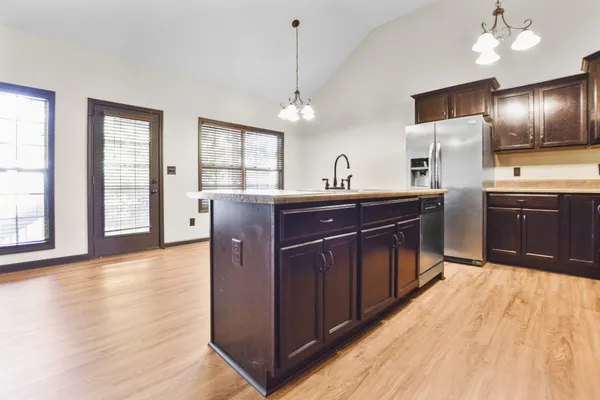 a kitchen with stainless steel appliances granite countertop a sink a stove and a wooden floors