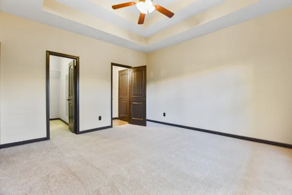 an empty room with chandelier fan