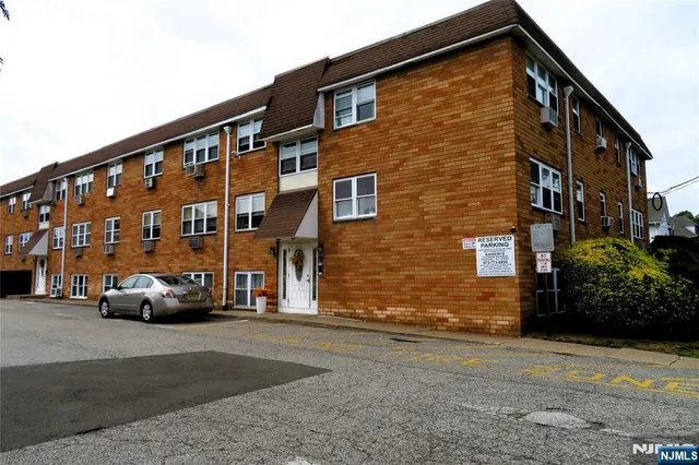 a view of building with car parked