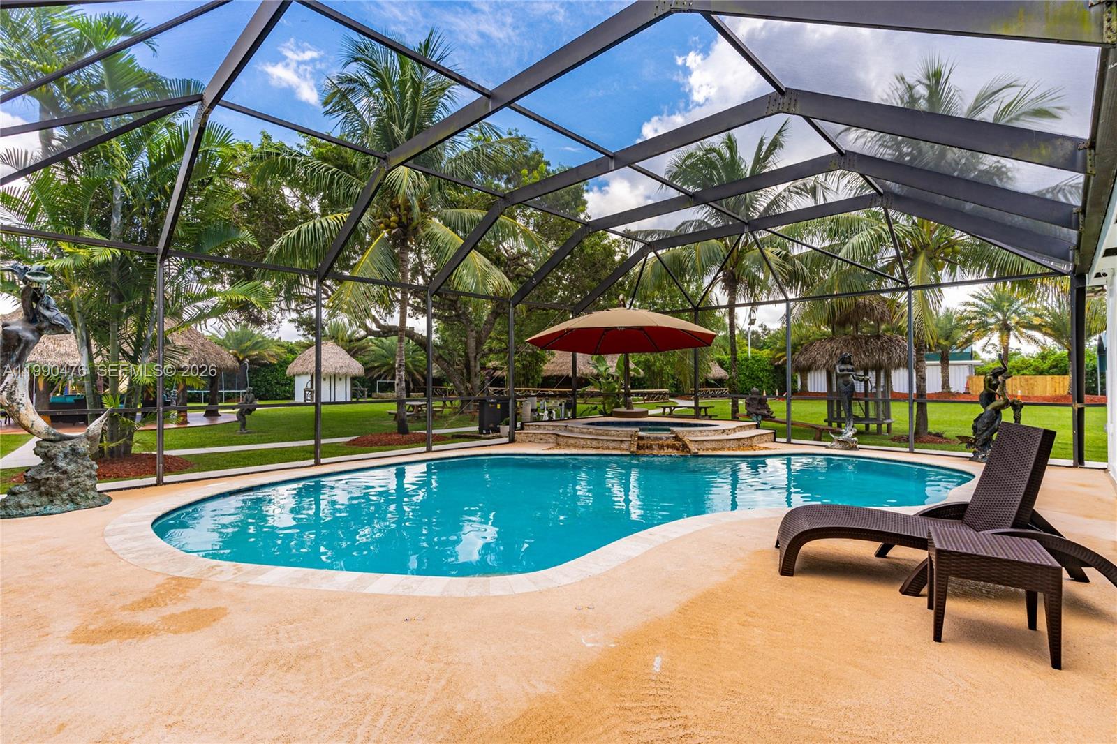 18851 Southwest 218th Street Miami, FL 33170 - Photo 21 of 27 a view of a swimming pool with a table and chairs under an umbrella