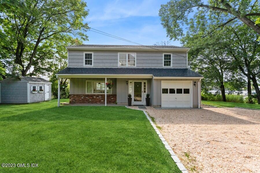 40 Chapel Lane Riverside, CT 06878 - Photo 4 of 35 a front view of a house with a garden and trees